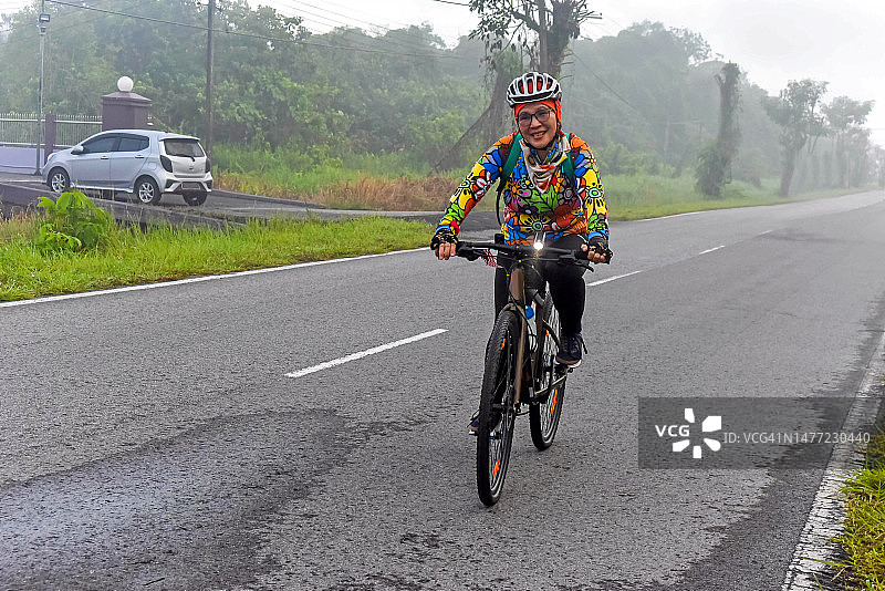 雾蒙蒙的早晨，亚洲女士骑自行车图片素材