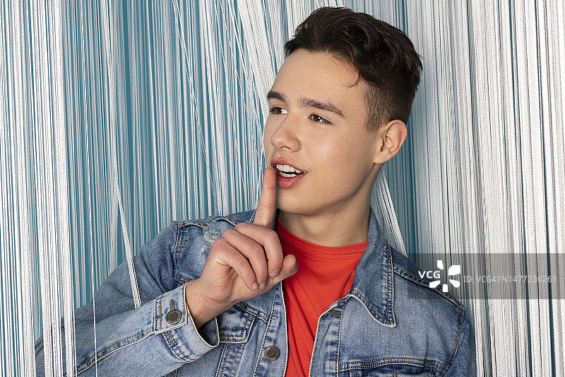 帅气青年男人穿牛仔服，线帘房间摆姿势图片素材