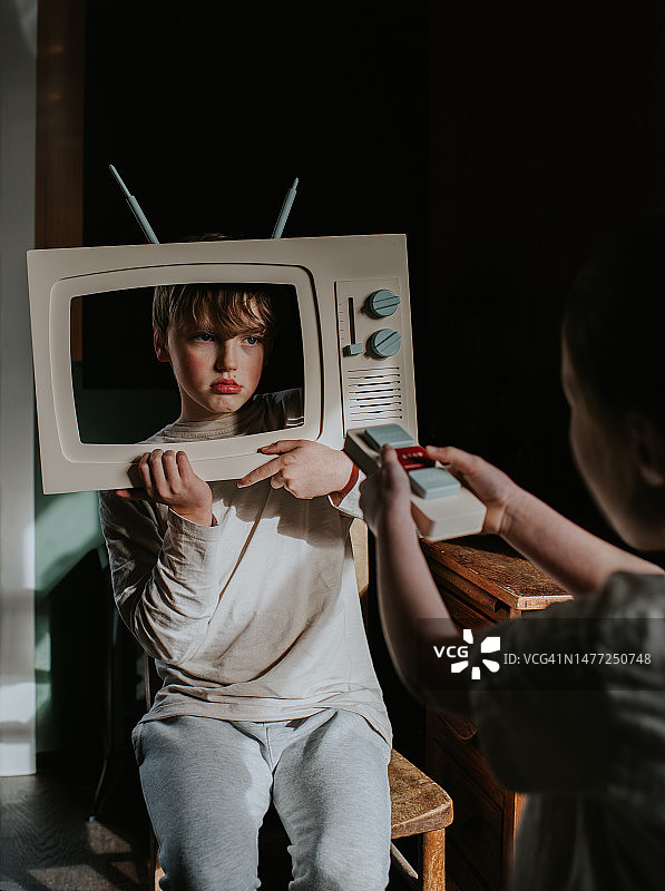 孩子们玩木制玩具电视，假装是自己节目的明星图片素材