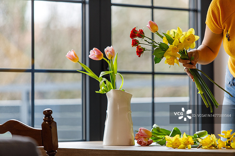 年轻女人整理春季鲜花花束图片素材