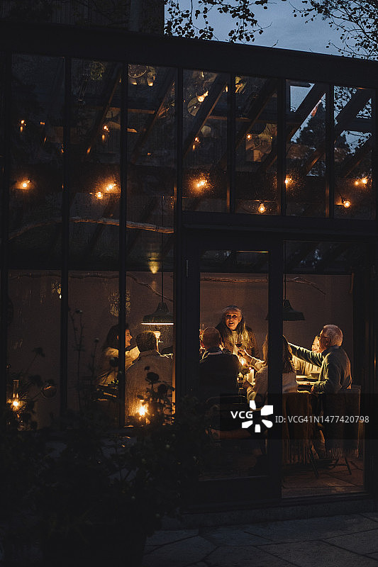 男女朋友在灯光璀璨的餐厅里享受夜晚派对图片素材