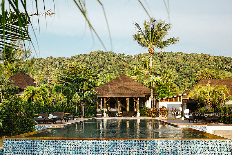 度假村别墅外的游泳池，绿树成荫图片素材
