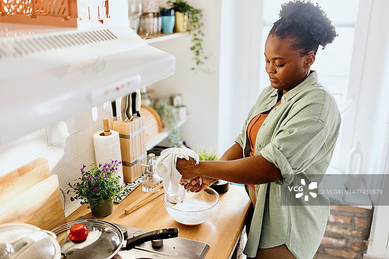 女人用布过滤杏仁奶图片素材
