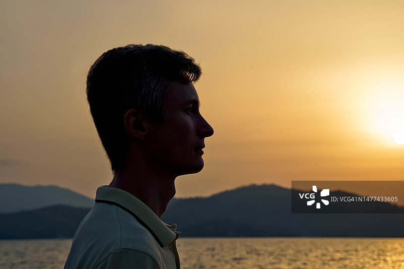 夕阳下的年轻男子轮廓剪影图片素材