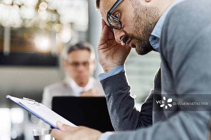 焦虑的男人在与经纪人会面时查看合同图片素材