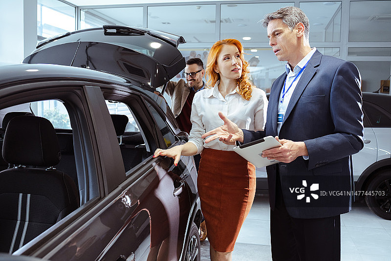 专业销售员在汽车经销店与顾客交谈图片素材