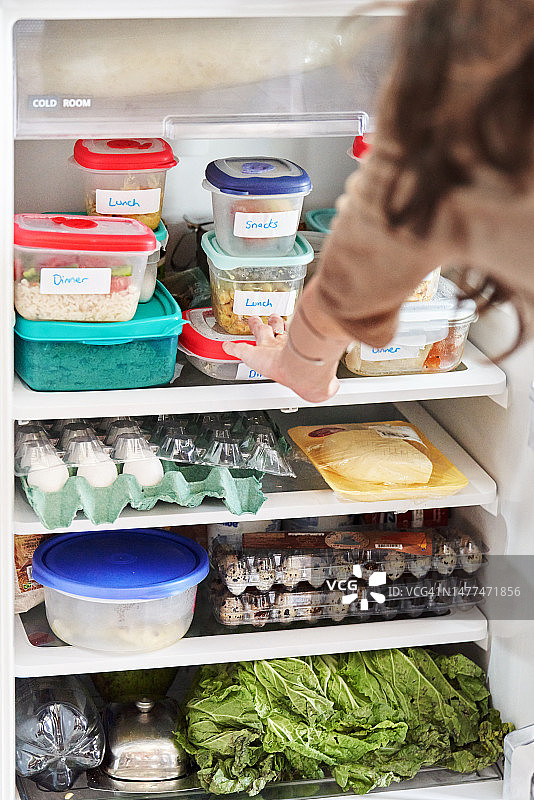 女人在家看冰箱里准备好的健康餐图片素材