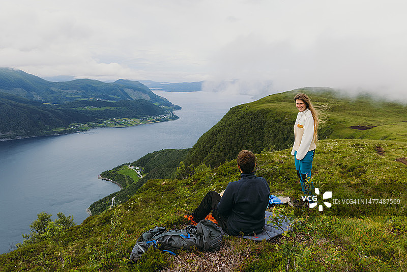 情侣欣赏挪威峡湾夏季美景侧视图图片素材