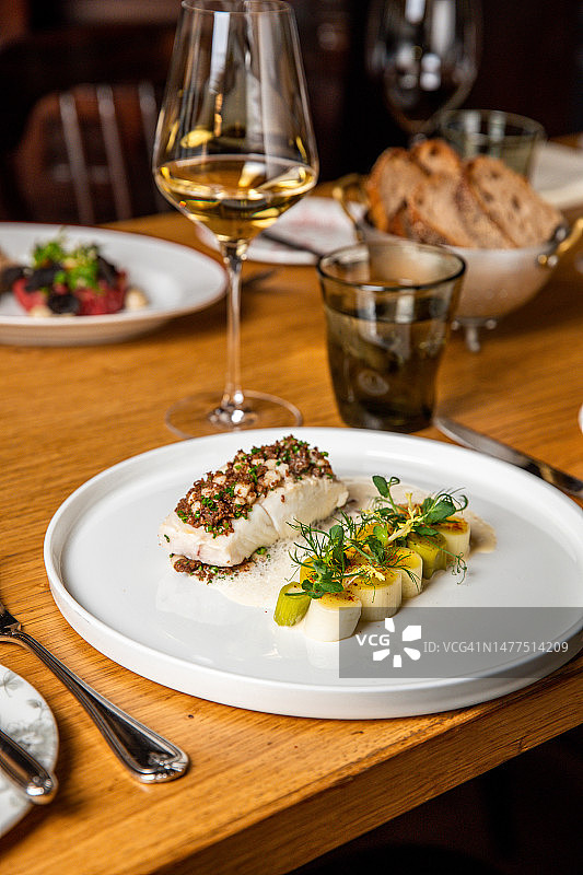 米其林餐厅美食：韭葱蔬菜香草鱼片图片素材