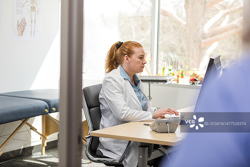 正在查看电脑中电子病历的儿科女医生图片素材