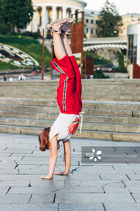 女孩在城市广场做倒立图片素材