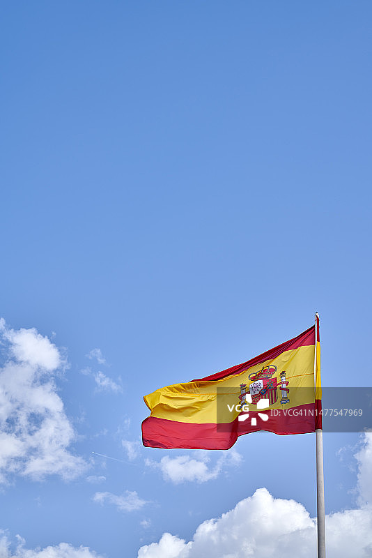 西班牙国旗在蓝天下飘扬图片素材