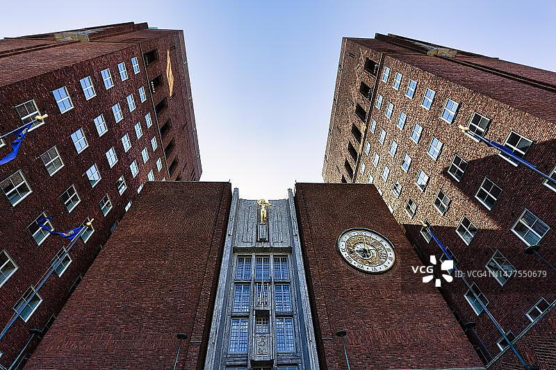 奥斯陆纪念红砖市政厅北侧外观：天文钟，建筑师阿恩斯坦·阿内伯格和马格努斯·波尔松作品，诺贝尔和平奖颁奖地，城市中心地标，逆光，挪威图片素材