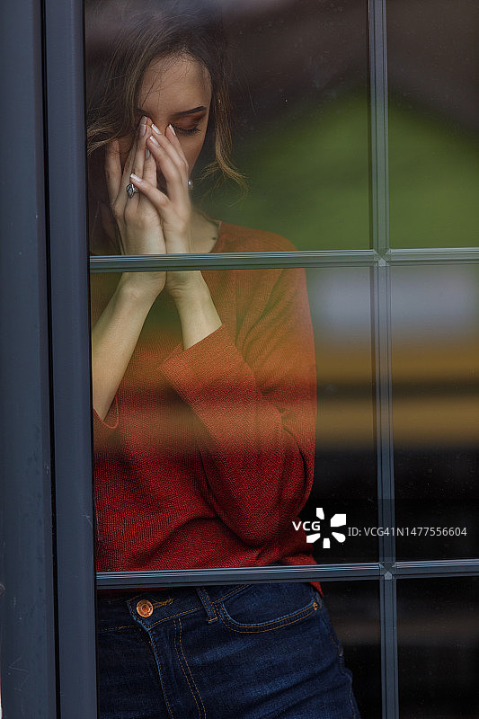 年轻女子向窗外看，焦虑，担心，沉思图片素材