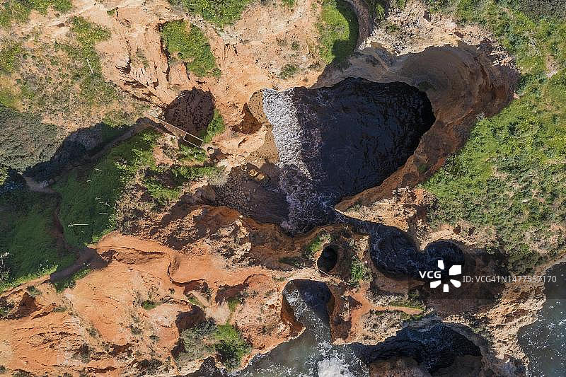 葡萄牙阿尔加维玛丽娜海滩的洞穴、岩石和悬崖陡峭海岸图片素材