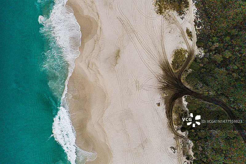 白色沙滩上的四驱车泥路和轮胎印鸟瞰图图片素材