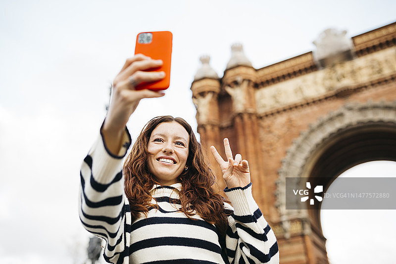 红发女人在巴塞罗那凯旋门自拍图片素材
