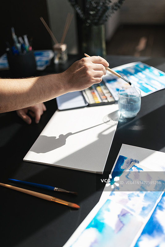 年轻人在家用水彩和纸作画，选择性聚焦，阳光明媚图片素材