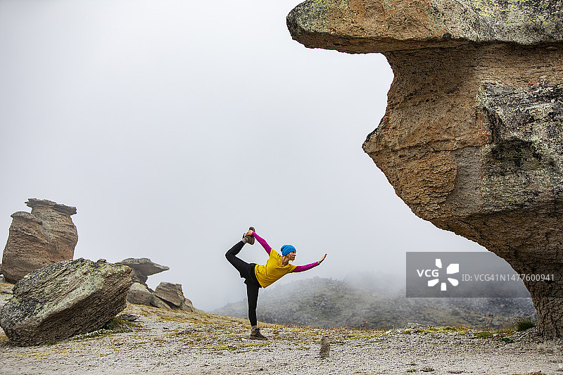 在山中练习瑜伽的年轻女人图片素材