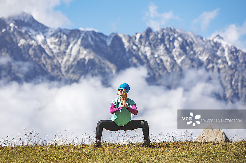 在山中练习瑜伽的年轻女人图片素材