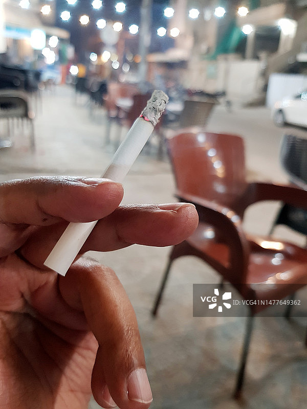 男人指间夹着香烟图片素材