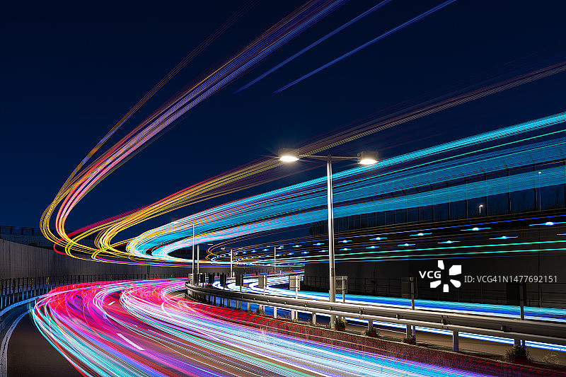 弯曲道路上空的彩色光轨图片素材