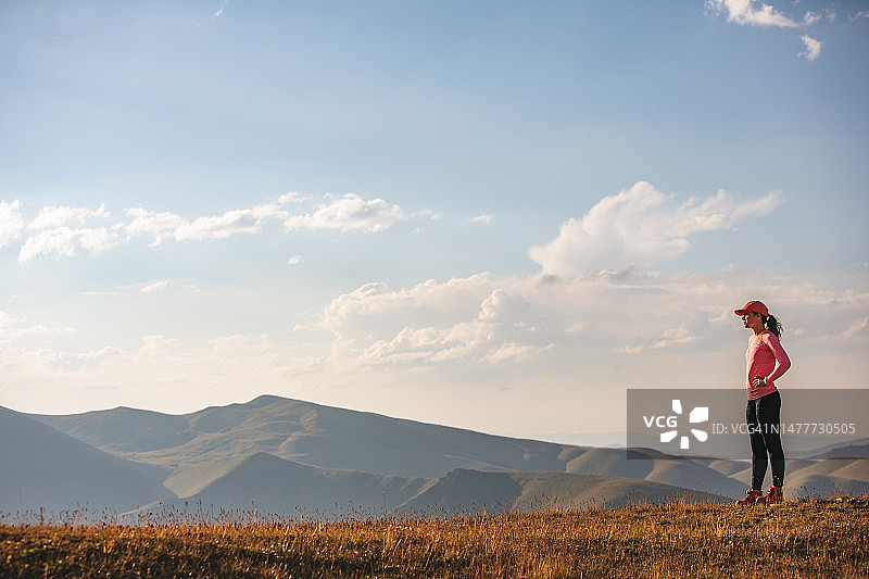 日落时分在山中奔跑的年轻女子图片素材