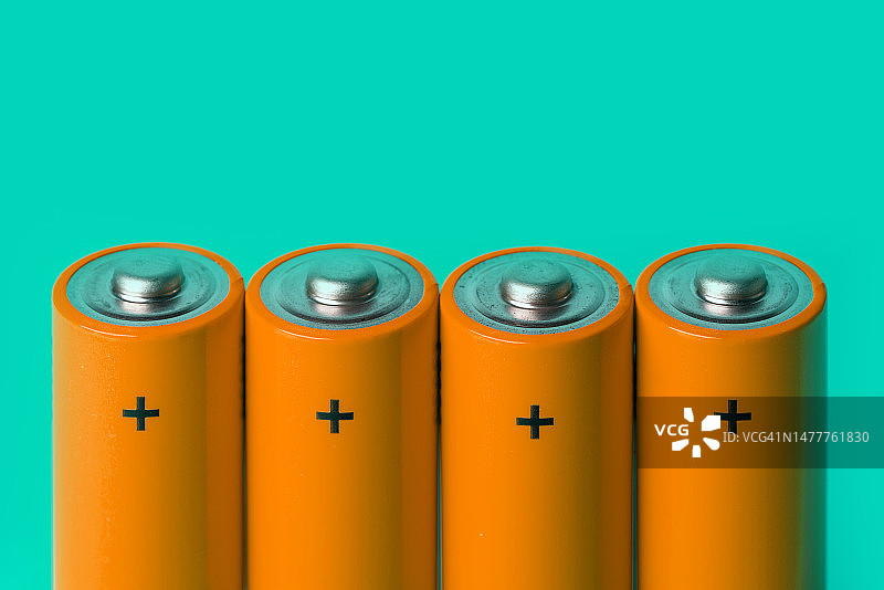 绿色背景上的四个橙色电池图片素材