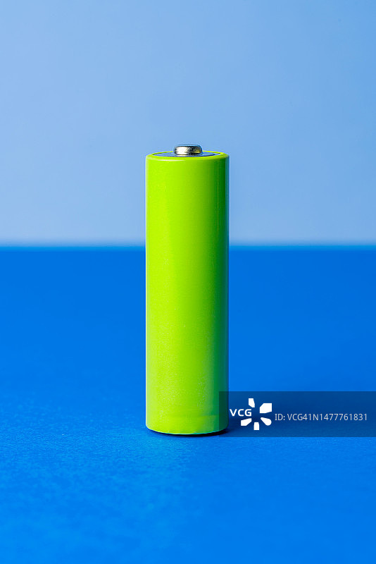 蓝色背景下的AA绿色充电电池图片素材