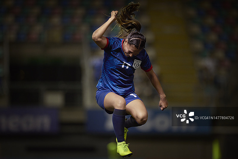 充满激情的国际足球运动员兴奋地跳跃并庆祝比赛中的关键时刻图片素材