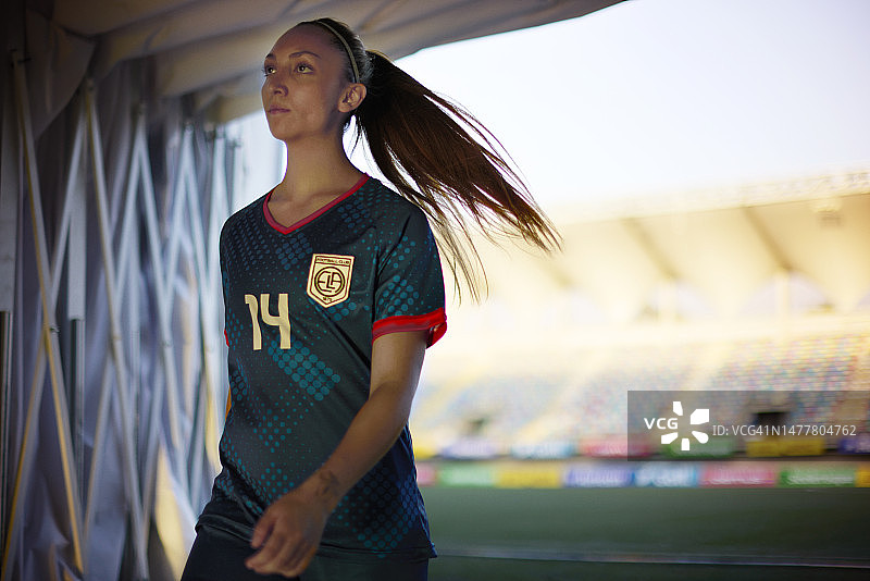 坚定的职业女足球运动员走过体育场隧道图片素材