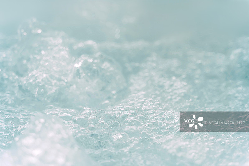 热水浴缸中的水泡特写。抽象液体背景。图片素材