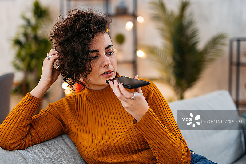 年轻女人在家发送语音消息图片素材