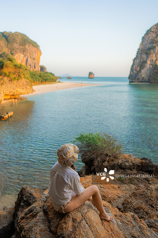 女人坐在岩石上，眺望莱利湾图片素材