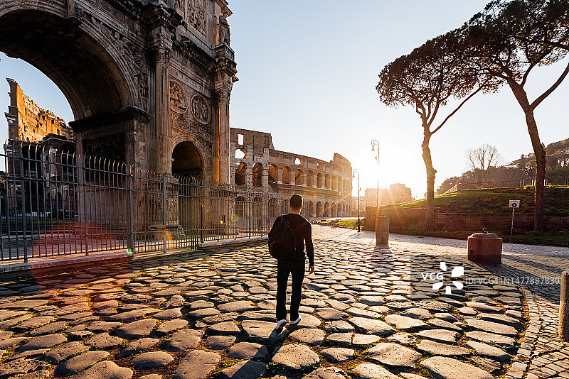 日出时在罗马探索古迹的男子背面图片素材