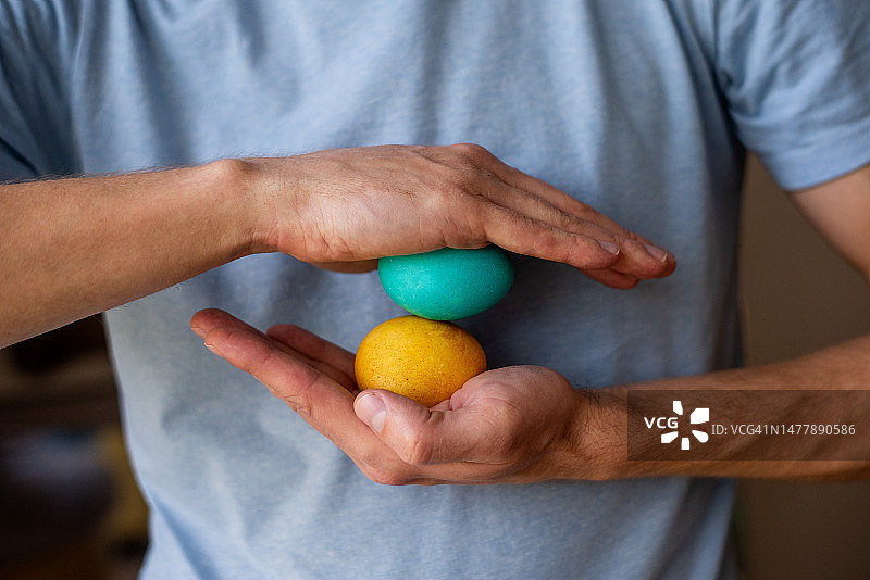 手捧蓝黄色复活节彩蛋的无脸男人。乌克兰国旗的颜色图片素材