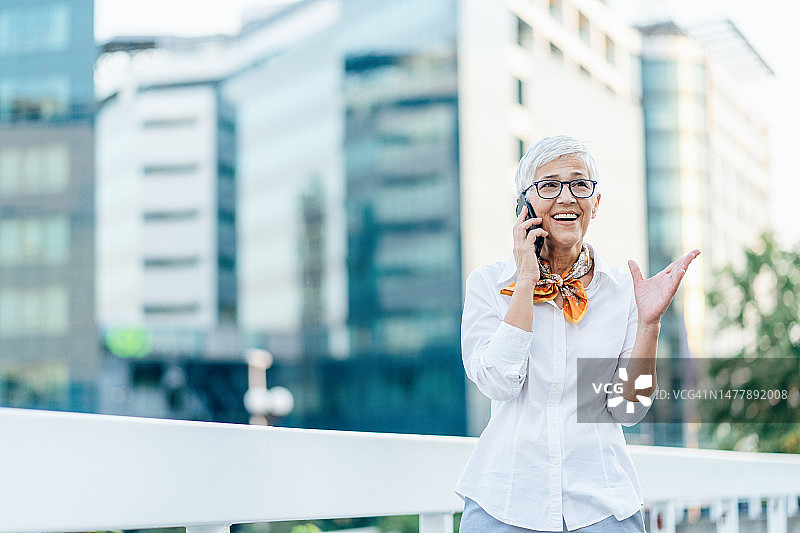 优雅的中年妇女正在打电话图片素材