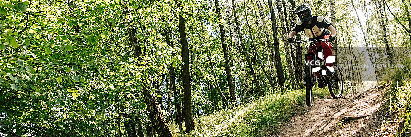 户外运动男子骑山地自行车速降，森林越野骑行图片素材