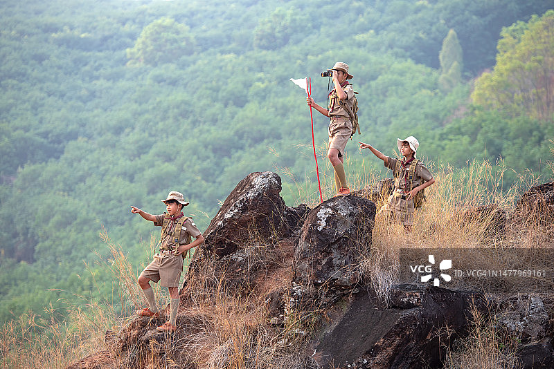 站在悬崖上的亚洲女童子军，三个童子军学生正在眺望图片素材