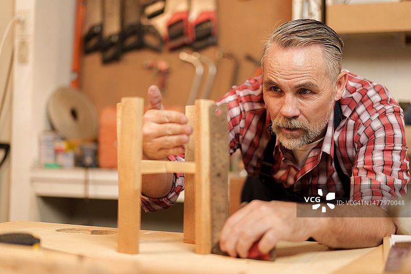 男子在商店里组装新的木制架子和家具图片素材