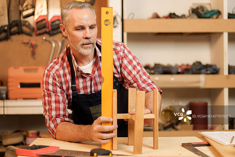男子在商店里组装新的木制架子和家具图片素材