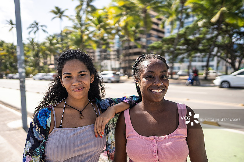快乐的女性朋友在海滩人行道上的人物肖像图片素材