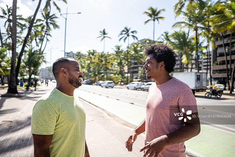 两位中年男性朋友在木板路上交谈图片素材