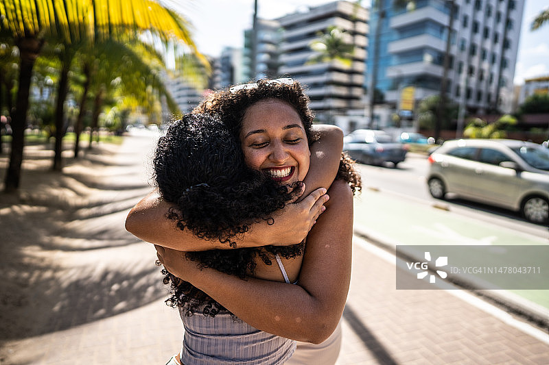 朋友在木板路上互相问候拥抱图片素材