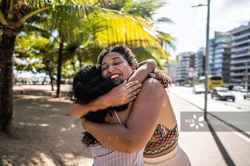 朋友在木板路上互相问候拥抱图片素材