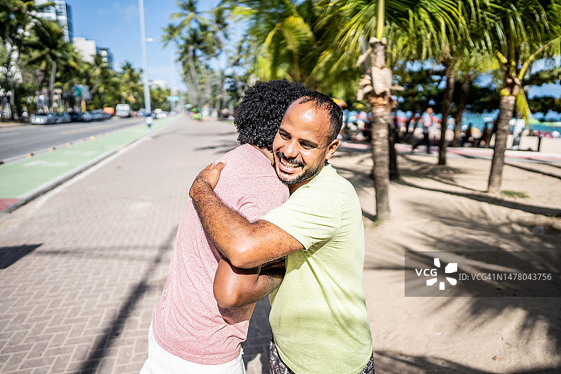 朋友在木板路上互相问候拥抱图片素材