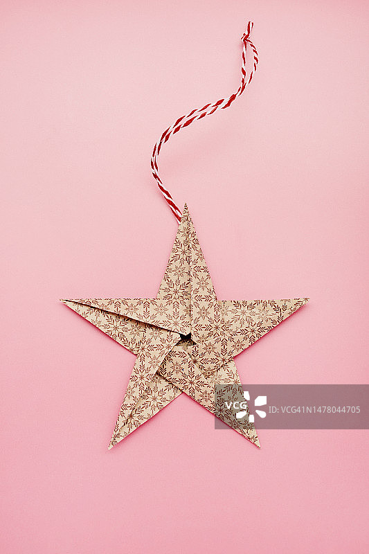 粉色背景上的圣诞装饰折纸纸星星图片素材