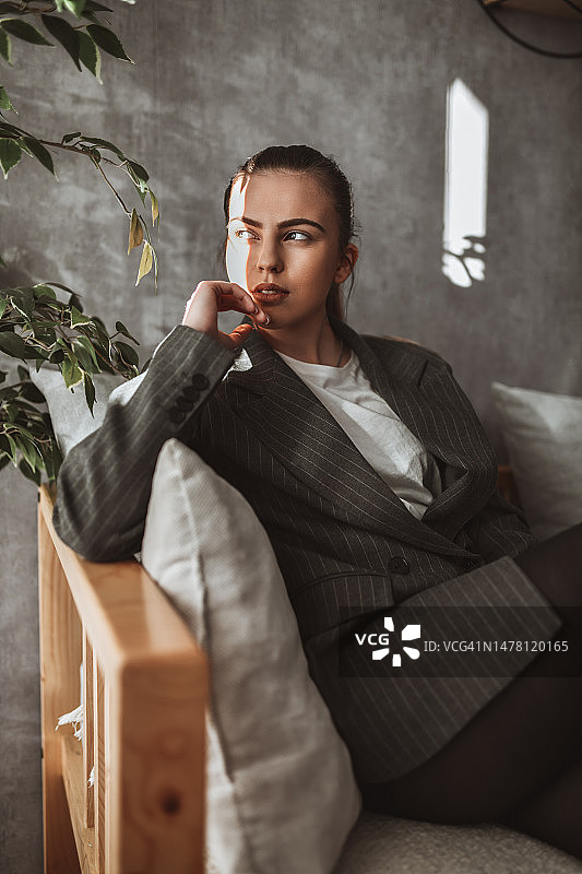 身穿西装在沙发上放松的美丽优雅女性图片素材