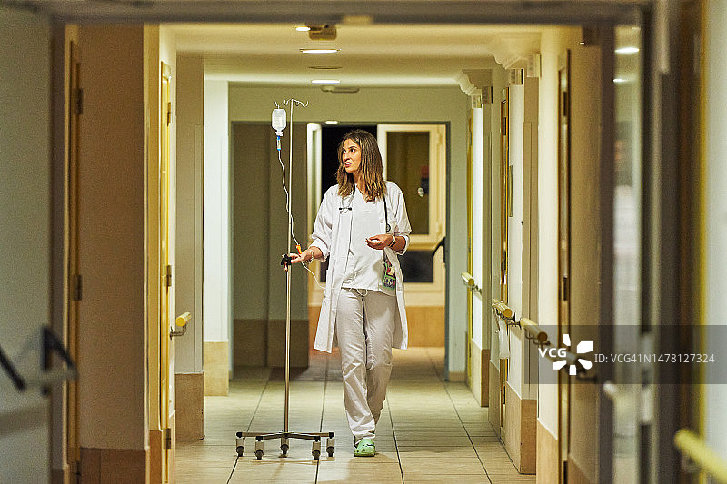 美女医生拿着静脉注射药袋走路图片素材
