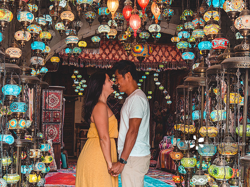 一对夫妇访问土耳其，走在卡帕多西亚的戈雷马街道上，他们站在一千盏灯下图片素材